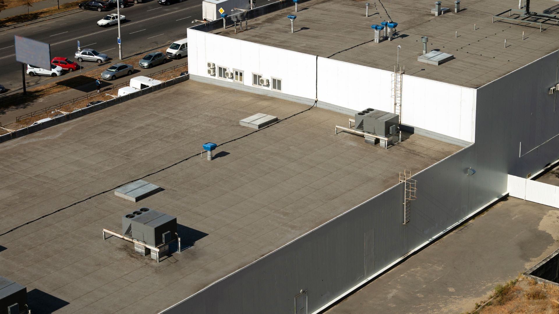 Aerial view of industrial building with flat roof and parking lot