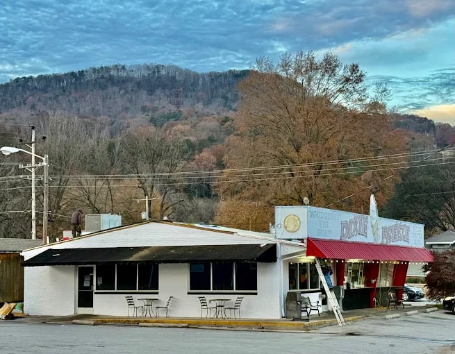 Small roadside cafe with mountain backdrop and autumn trees